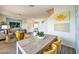 Stylish dining area with a modern table, seating, and elegant leaf artwork, opening to a living area at 7915 Pandora Sky St # 402, North Las Vegas, NV 89084