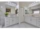 Bright bathroom has double vanities, white cabinets, large mirrors, and modern lighting fixtures at 8221 Bay Dunes St, Las Vegas, NV 89131