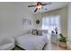 Cozy bedroom features a ceiling fan, wood floors, and a bright window with sheer curtains at 8221 Bay Dunes St, Las Vegas, NV 89131