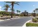 Community entrance with palm trees, landscaping, and a guard house at 8221 Bay Dunes St, Las Vegas, NV 89131