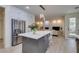 Open concept kitchen with gray island, stainless steel refrigerator, and pendant lighting at 8221 Bay Dunes St, Las Vegas, NV 89131