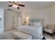 Bright primary bedroom with wood look tile, ceiling fan, and a view into the en suite bathroom at 8221 Bay Dunes St, Las Vegas, NV 89131