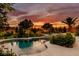 Inviting backyard pool with lush landscaping and a beautiful sunset backdrop at 8221 Bay Dunes St, Las Vegas, NV 89131