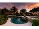 Beautiful backyard pool and spa surrounded by lush landscaping, creating a private oasis at sunset at 8221 Bay Dunes St, Las Vegas, NV 89131