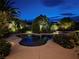 A beautiful backyard pool and spa are surrounded by lush landscaping, creating a private oasis at nighttime at 8221 Bay Dunes St, Las Vegas, NV 89131