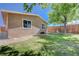 The backyard features lush green grass, mature trees for shade, and a well-maintained fence for privacy at 839 Benita Pl, Boulder City, NV 89005