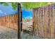 View of arid desert landscape through open backyard gate framed by mature foliage at 839 Benita Pl, Boulder City, NV 89005