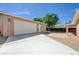 Spacious driveway leading to a detached garage with ample parking and mature trees for shade at 839 Benita Pl, Boulder City, NV 89005