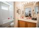 Bright bathroom features a tub/shower combo, white tile, and a sink vanity with storage at 8437 Cinnamon Hill Ave, Las Vegas, NV 89129