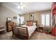 Cozy bedroom with a wood frame bed, plush carpet, and natural light from shuttered windows at 8437 Cinnamon Hill Ave, Las Vegas, NV 89129