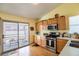 Functional kitchen with stainless steel appliances, wood cabinetry, and access to the outdoor patio at 8437 Cinnamon Hill Ave, Las Vegas, NV 89129