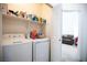 Practical laundry room with washer, dryer, and storage shelving for organization at 8437 Cinnamon Hill Ave, Las Vegas, NV 89129