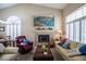 Bright living room featuring a tiled fireplace, comfortable seating, and natural light from large windows at 8437 Cinnamon Hill Ave, Las Vegas, NV 89129