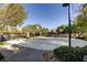 Community basketball court in a fenced area surrounded by mature trees and manicured landscape at 9192 Moose Country Pl, Las Vegas, NV 89178