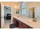 Bathroom boasting double sinks, vanity mirror, and an open doorway to the bedroom at 9192 Moose Country Pl, Las Vegas, NV 89178