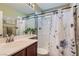 This bathroom has a shower and tub combination with a decorative shower curtain and ample vanity space at 9192 Moose Country Pl, Las Vegas, NV 89178