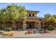 Community clubhouse featuring stone accents, mature trees, and lush landscaping at 9192 Moose Country Pl, Las Vegas, NV 89178