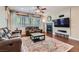Cozy living room with a fireplace, ceiling fan, and large windows for natural light at 9192 Moose Country Pl, Las Vegas, NV 89178