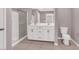 Bright bathroom featuring double vanity, shower with glass door, and tile floors at 9330 Brookmont Ave, Las Vegas, NV 89149