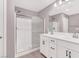 Bright bathroom featuring double vanity, shower with glass door, and tile floors at 9330 Brookmont Ave, Las Vegas, NV 89149