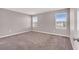 Empty bedroom with neutral carpet and two large windows at 9330 Brookmont Ave, Las Vegas, NV 89149