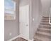Staircase with neutral carpet next to a white interior door and a window at 9330 Brookmont Ave, Las Vegas, NV 89149