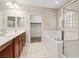 Bathroom with double sinks, soaking tub, separate shower, and tiled floors at 1008 New Creek Ave, Henderson, NV 89015