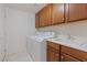 Laundry room with upper cabinets, laundry sink, and tiled floors at 1008 New Creek Ave, Henderson, NV 89015
