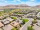 Aerial view of a residential neighborhood with well-manicured lawns and mature trees against a mountain backdrop at 10315 Turia Gardens Rd, Las Vegas, NV 89135