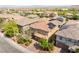 Aerial view of a home with solar panels, surrounded by lush landscaping and neighborhood homes at 10315 Turia Gardens Rd, Las Vegas, NV 89135