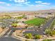 Aerial view of a well-maintained school campus with a large sports field and parking lot surrounded by desert landscaping at 10315 Turia Gardens Rd, Las Vegas, NV 89135