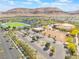 Aerial view of a school, sports field, mountains, and a parking lot in a residential neighborhood at 10315 Turia Gardens Rd, Las Vegas, NV 89135