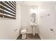 Powder room with a pedestal sink, oval mirror, and earth tone tile flooring at 10315 Turia Gardens Rd, Las Vegas, NV 89135