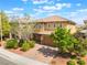 A beautifully landscaped two-story house with a well-manicured lawn and a paved driveway at 10315 Turia Gardens Rd, Las Vegas, NV 89135