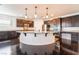 Bright kitchen with a large island, dark wood cabinetry, stainless steel appliances and pendant lighting at 10315 Turia Gardens Rd, Las Vegas, NV 89135