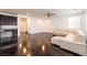 Spacious living area with dark wood floors, a comfortable white sofa and a ceiling fan at 10315 Turia Gardens Rd, Las Vegas, NV 89135