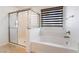 Bathroom features a separate shower and soaking tub next to a window at 10315 Turia Gardens Rd, Las Vegas, NV 89135