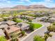 Aerial view showcases the neighborhood's homes with solar panels, surrounded by lush trees and green lawns at 10315 Turia Gardens Rd, Las Vegas, NV 89135