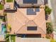 Aerial view of a home with a tile roof and solar panels, near an inviting swimming pool and well-kept lawn at 10315 Turia Gardens Rd, Las Vegas, NV 89135