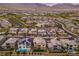 Expansive aerial view of a modern neighborhood featuring houses with solar panels against a mountain backdrop at 12367 Aster Hills Ave, Las Vegas, NV 89138