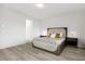 Modern bedroom with cozy bed, neutral tones, wood floors, and minimalist decor creating a serene retreat at 12367 Aster Hills Ave, Las Vegas, NV 89138