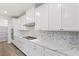Bright kitchen features white cabinets, quartz countertops, gas cooktop, mosaic backsplash, and stainless steel appliances at 12367 Aster Hills Ave, Las Vegas, NV 89138