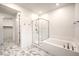 Bathroom with a combined shower and tub, white tile and floors, and sleek glass doors at 12404 Aster Hills Ave, Las Vegas, NV 89138