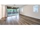 A bright bedroom with wood floors and sliding glass doors leading to a balcony with views at 12404 Aster Hills Ave, Las Vegas, NV 89138