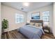 Bright bedroom with a comfy blue bed, stylish decor, and modern wood-look floors at 12404 Aster Hills Ave, Las Vegas, NV 89138