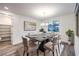 Dining room boasts a modern table set, stylish decor, a large window, and new-looking laminate floors at 12404 Aster Hills Ave, Las Vegas, NV 89138