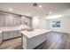 Spacious kitchen featuring a large island, gray cabinetry, and modern lighting at 12404 Aster Hills Ave, Las Vegas, NV 89138