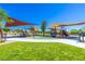 Community playground featuring covered play structures, walking path, and lush green grass at 12404 Aster Hills Ave, Las Vegas, NV 89138