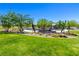 Community playground with lush green grass and covered play structures surrounded by desert landscaping at 12404 Aster Hills Ave, Las Vegas, NV 89138
