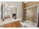 Light brown vanity featuring a bathtub and glass shower door, and neutral color scheme at 1383 Opal Valley St, Henderson, NV 89052